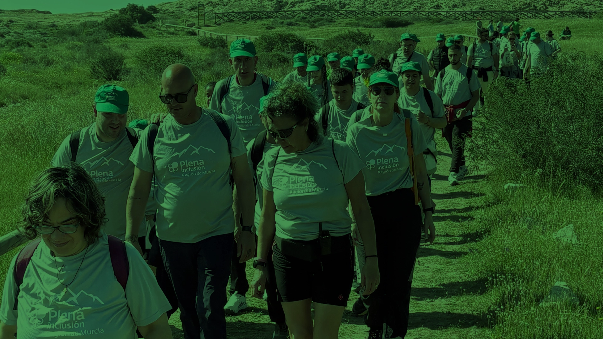 Grupo de personas caminando por un sendero al aire libre.